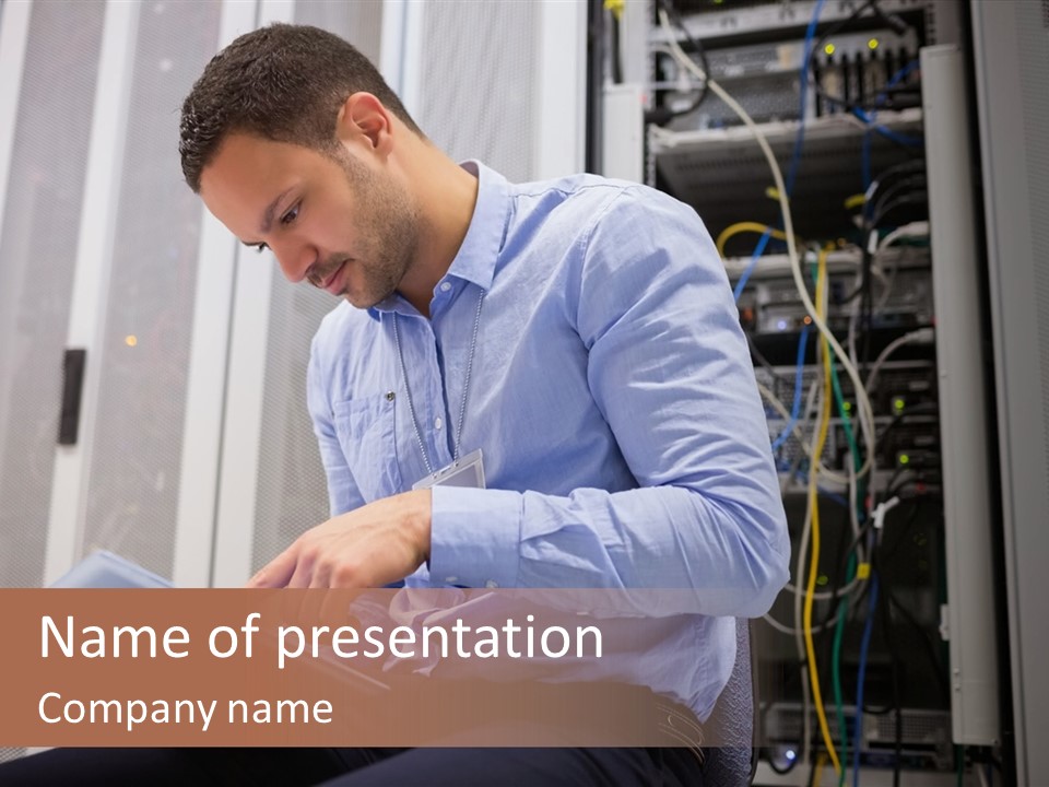 A Man Sitting In Front Of A Server In A Server Room PowerPoint Template