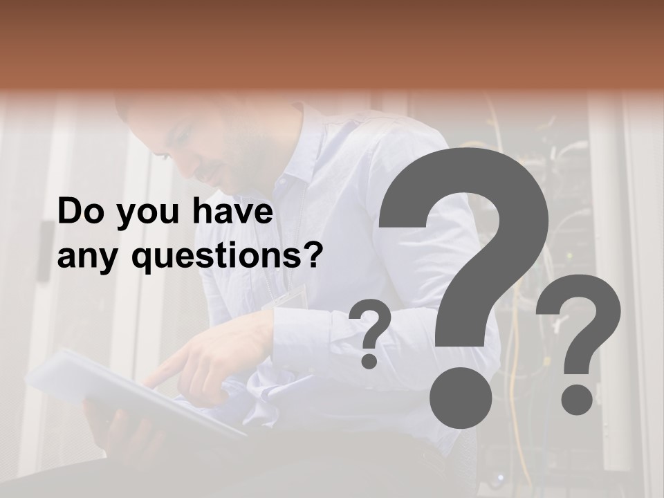 A Man Sitting In Front Of A Server In A Server Room PowerPoint Template