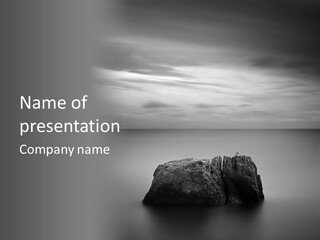 A Black And White Photo Of A Rock In The Ocean PowerPoint Template