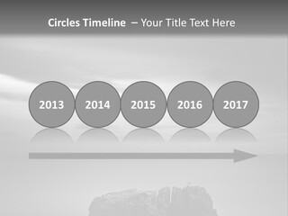 A Black And White Photo Of A Rock In The Ocean PowerPoint Template