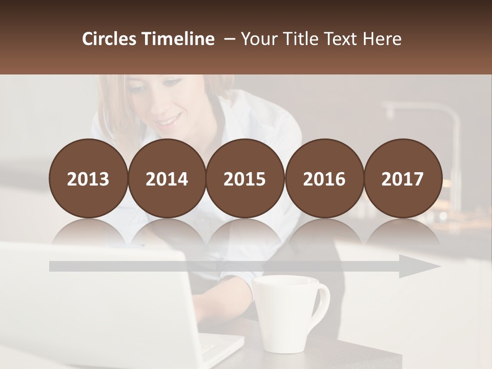 A Woman Sitting At A Table Using A Laptop Computer PowerPoint Template