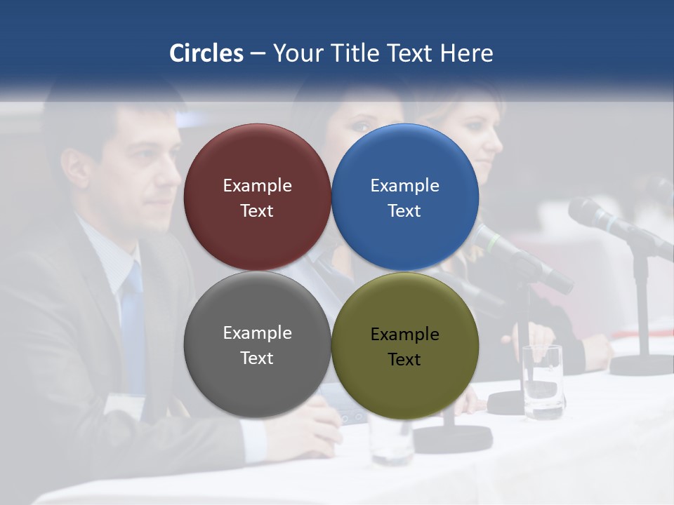 A Group Of People Sitting At A Table With Microphones PowerPoint Template