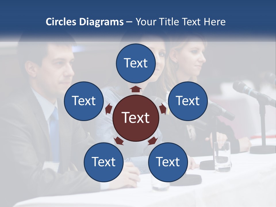 A Group Of People Sitting At A Table With Microphones PowerPoint Template