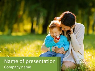 A Woman Holding A Baby In A Field Of Grass PowerPoint Template