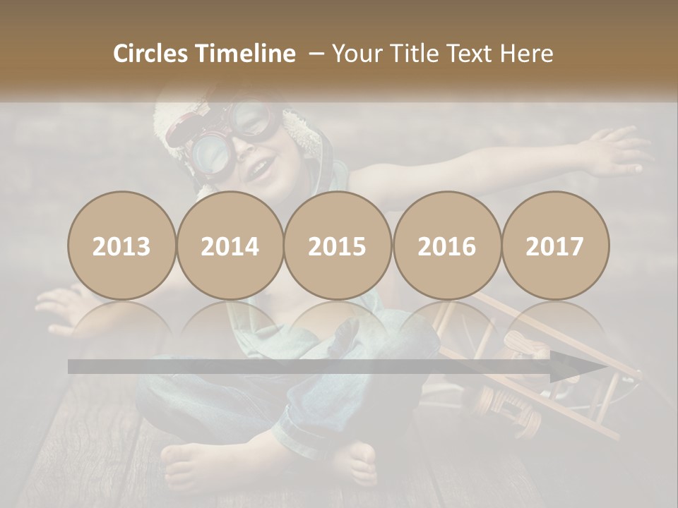 A Young Boy In A Hat And Scarf Sitting On A Wooden Floor PowerPoint Template