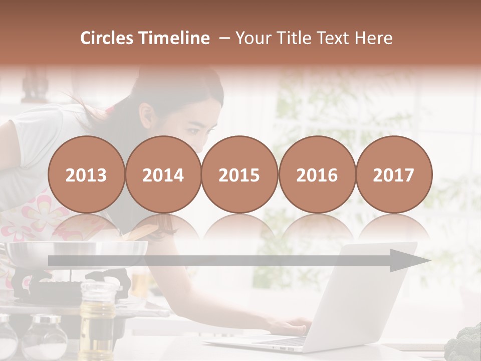 A Woman Using A Laptop On A Kitchen Counter PowerPoint Template