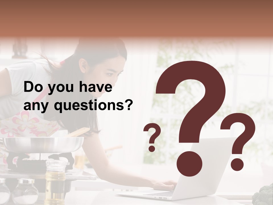 A Woman Using A Laptop On A Kitchen Counter PowerPoint Template