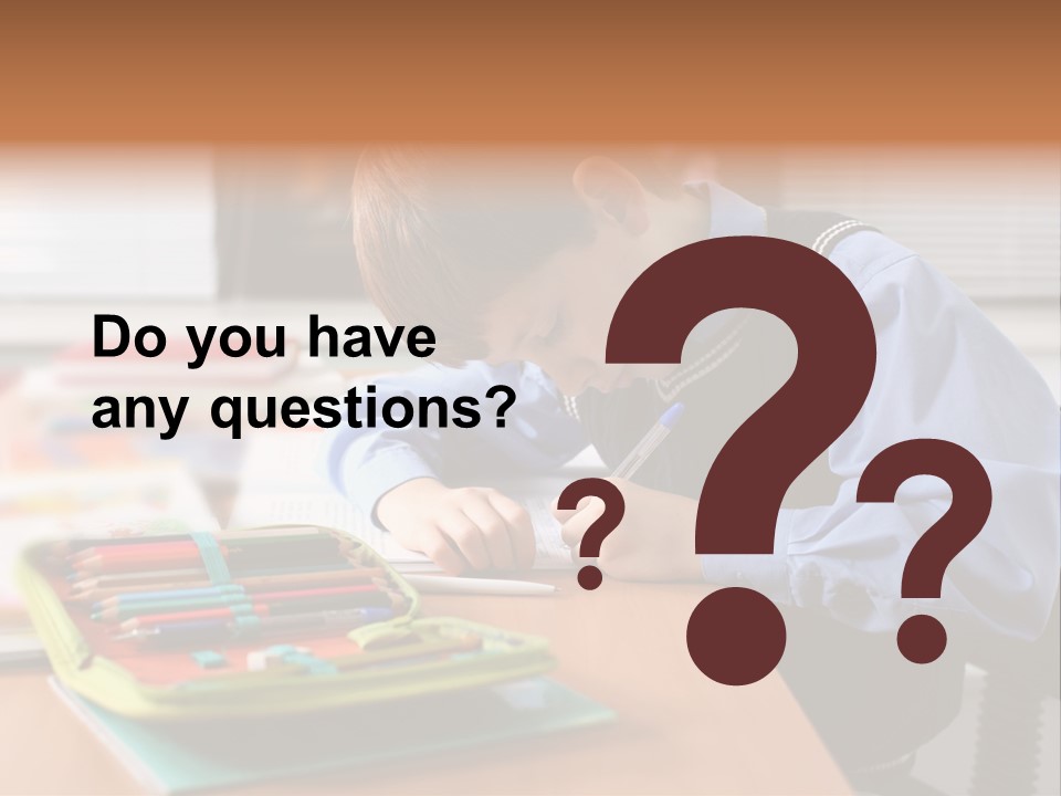 A Young Boy Writing On A Piece Of Paper PowerPoint Template