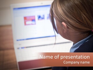 A Young Girl Is Looking At A Computer Screen PowerPoint Template