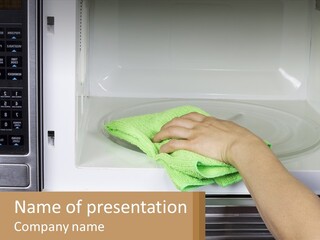 A Person Cleaning A Microwave With A Green Towel PowerPoint Template