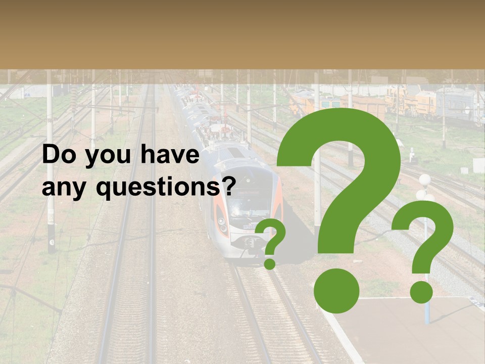 A Train Traveling Down Train Tracks Next To A Field PowerPoint Template
