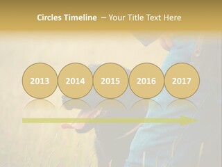 A Person Holding A Black Dog In A Field PowerPoint Template