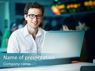 A Man Sitting In Front Of A Laptop Computer PowerPoint Template