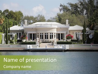A Large White House Sitting Next To A Body Of Water PowerPoint Template