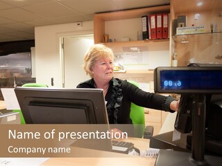 A Woman Sitting At A Desk In Front Of A Computer PowerPoint Template