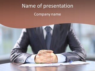 A Man In A Suit Sitting At A Table With His Hands Folded PowerPoint Template