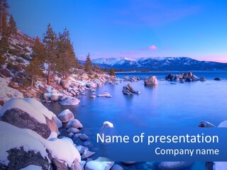 A Rocky Shore With Snow On The Rocks And Mountains In The Background PowerPoint Template