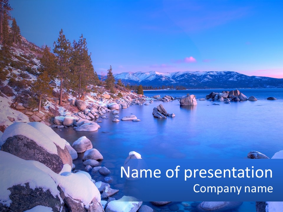 A Rocky Shore With Snow On The Rocks And Mountains In The Background PowerPoint Template
