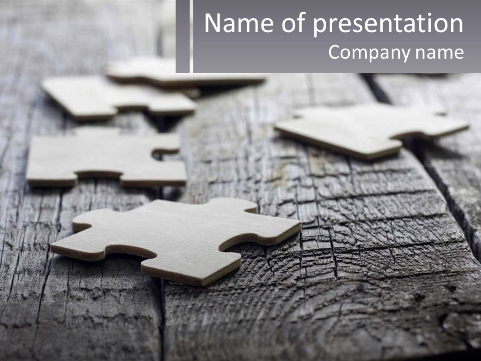 A Group Of Pieces Of A Puzzle On A Wooden Table PowerPoint Template