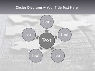 A Group Of Pieces Of A Puzzle On A Wooden Table PowerPoint Template