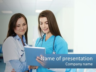 Two Women In Scrubs Are Looking At A Tablet PowerPoint Template