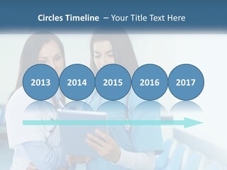 Two Women In Scrubs Are Looking At A Tablet PowerPoint Template