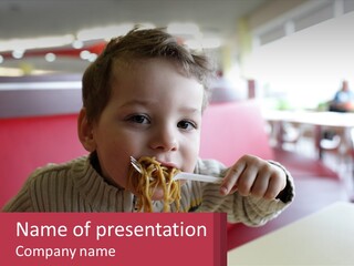 A Young Boy Eating Noodles In A Restaurant PowerPoint Template