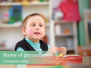 A Young Boy Is Sitting At A Table PowerPoint Template