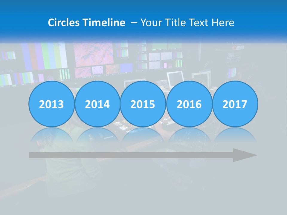 A Group Of People Sitting At A Desk With Computers PowerPoint Template