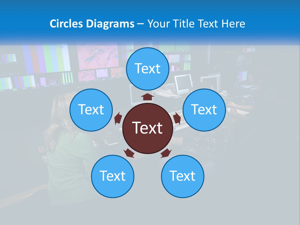 A Group Of People Sitting At A Desk With Computers PowerPoint Template