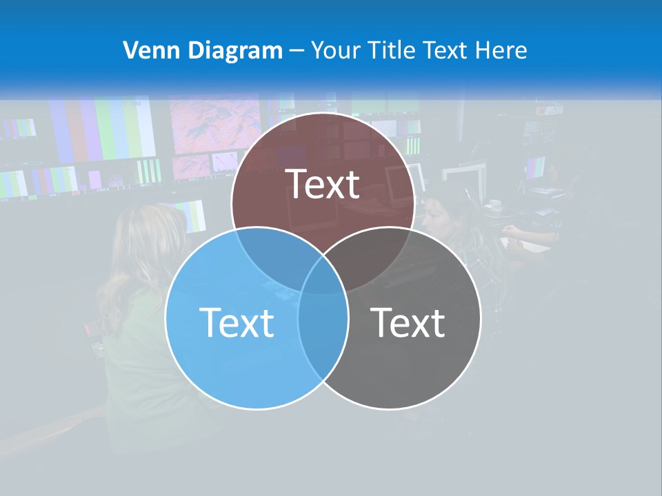 A Group Of People Sitting At A Desk With Computers PowerPoint Template