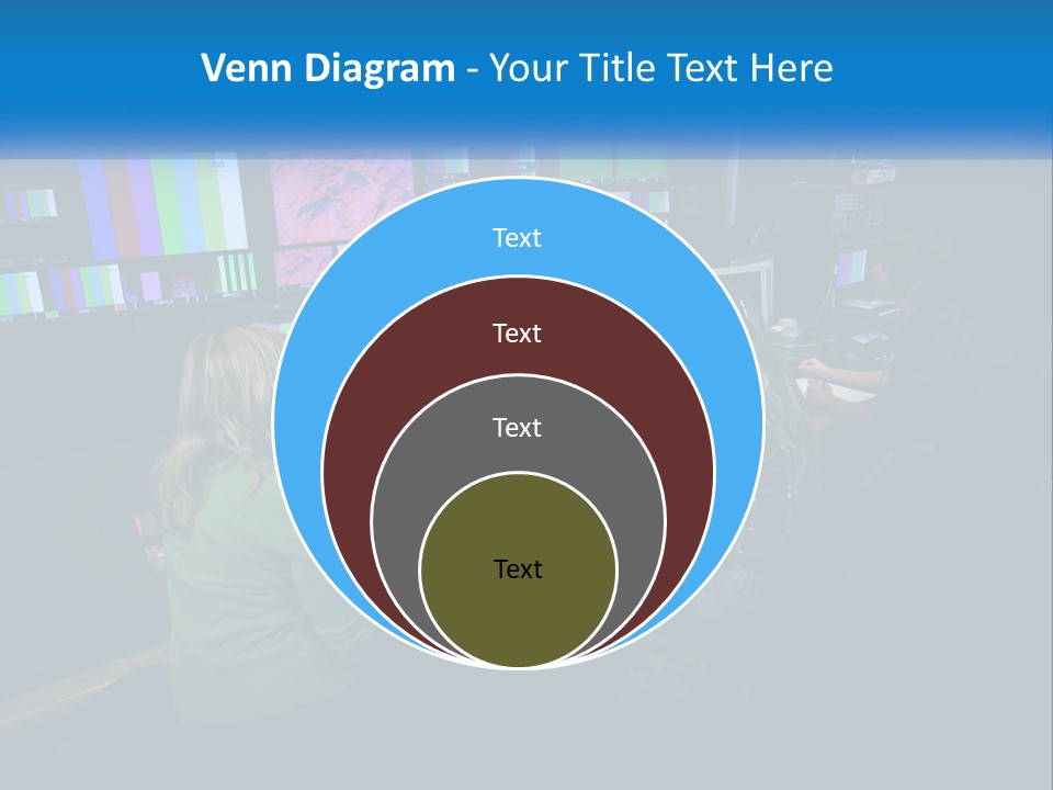A Group Of People Sitting At A Desk With Computers PowerPoint Template