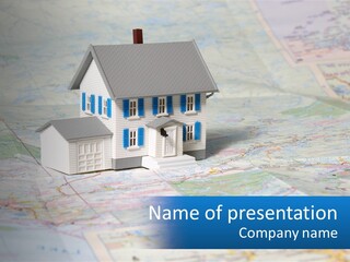 A Small Model House Sitting On Top Of A Map PowerPoint Template