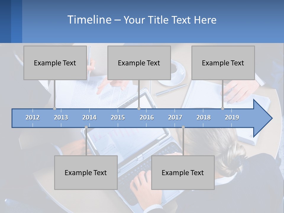 A Group Of People Sitting Around A Table Working On A Laptop PowerPoint Template