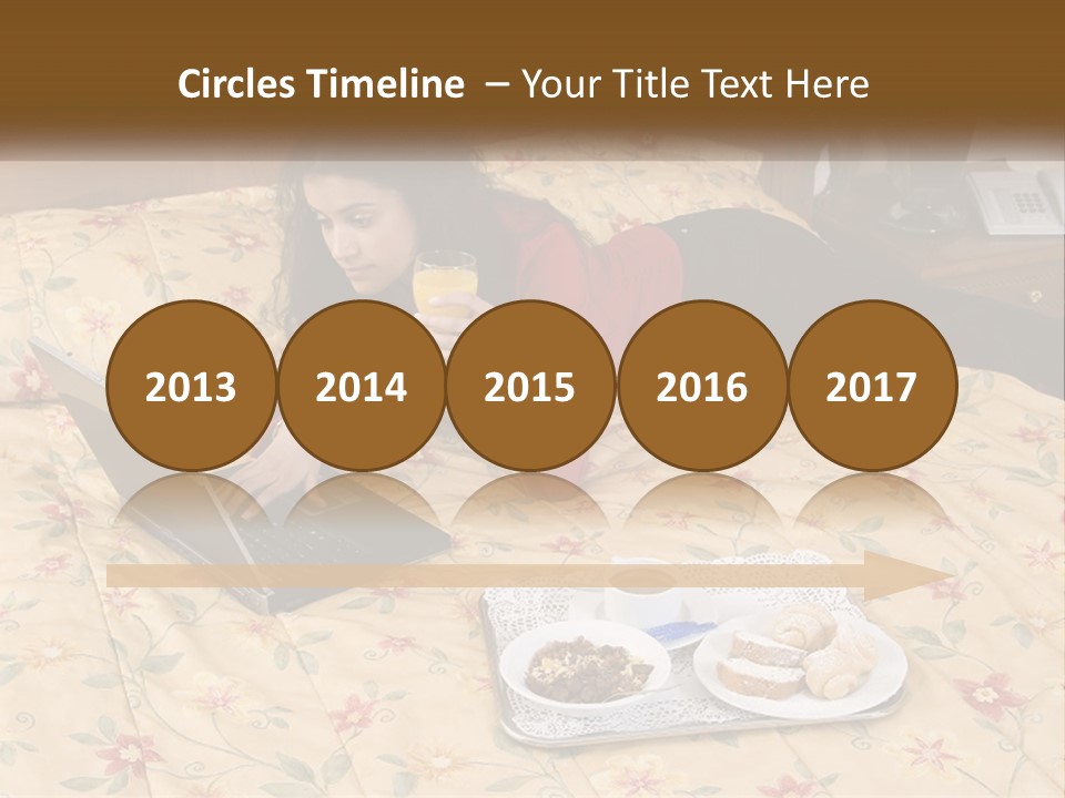 A Woman Laying On A Bed With A Laptop And A Glass Of Orange Juice PowerPoint Template