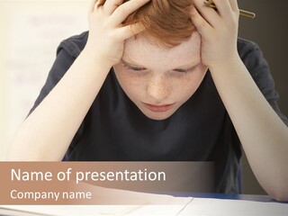 A Young Boy Sitting At A Desk With His Hands On His Head PowerPoint Template