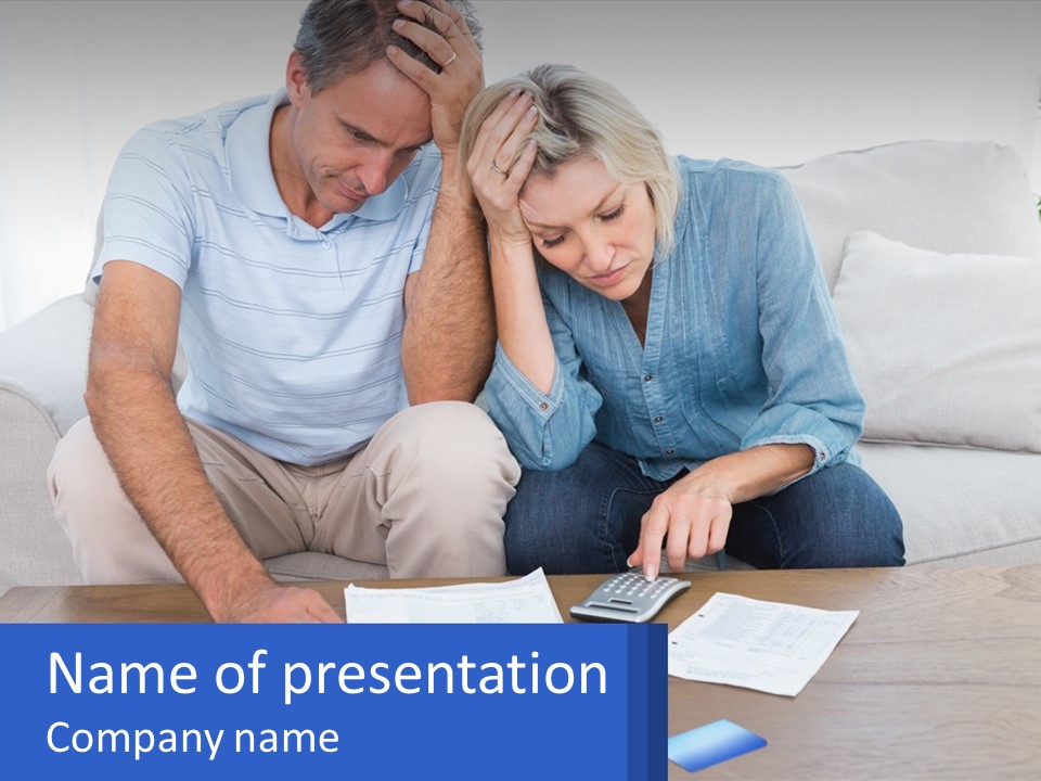 A Man And Woman Sitting On A Couch Looking At A Calculator PowerPoint Template