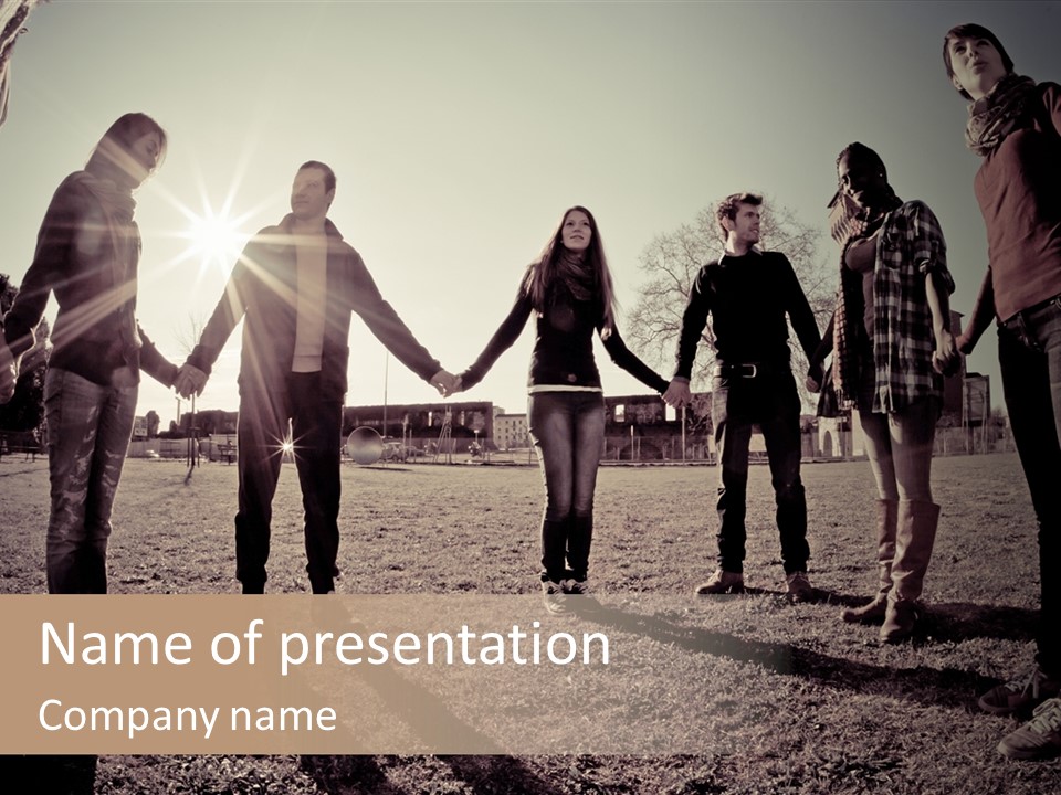 A Group Of People Holding Hands In A Field PowerPoint Template