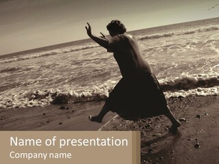 A Woman Walking On The Beach With Her Arms In The Air PowerPoint Template