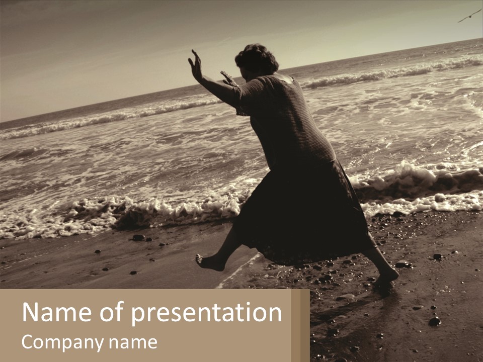 A Woman Walking On The Beach With Her Arms In The Air PowerPoint Template