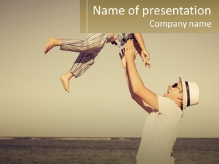 A Man Holding A Child Up In The Air PowerPoint Template