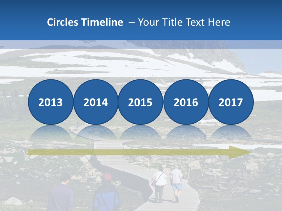 A Group Of People Walking Down A Path Towards A Mountain PowerPoint Template