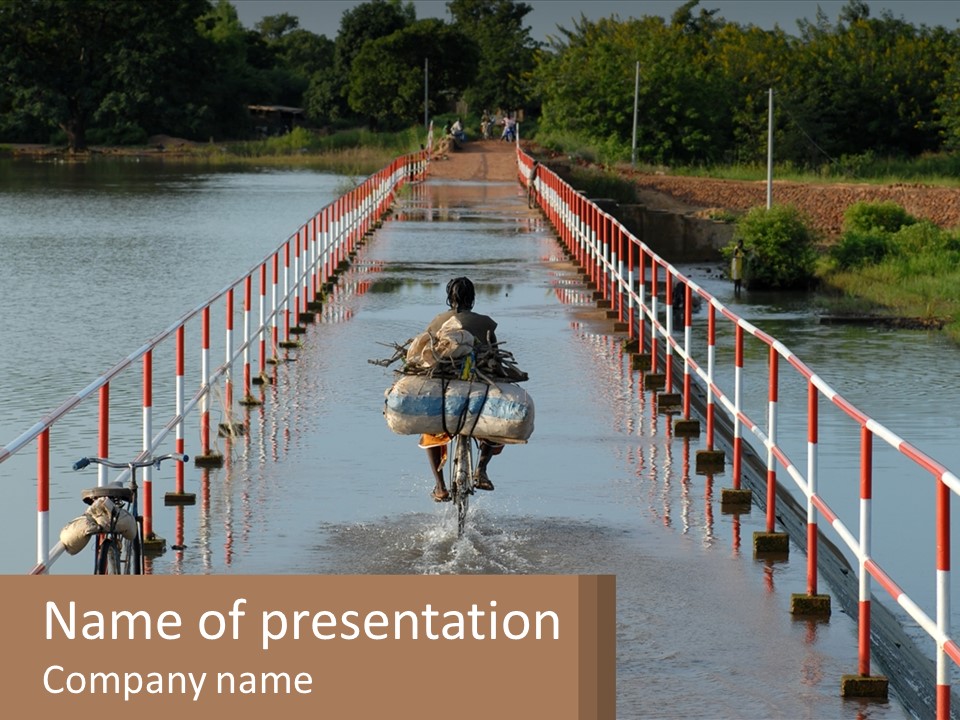 A Person Riding A Bike Across A Flooded Bridge PowerPoint Template