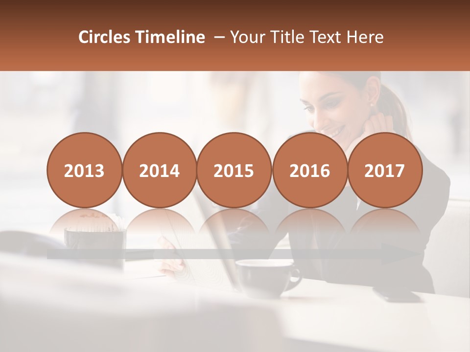 A Woman Sitting At A Table Using A Laptop Computer PowerPoint Template