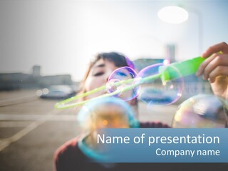 A Young Girl Blowing Bubbles With Her Hands PowerPoint Template