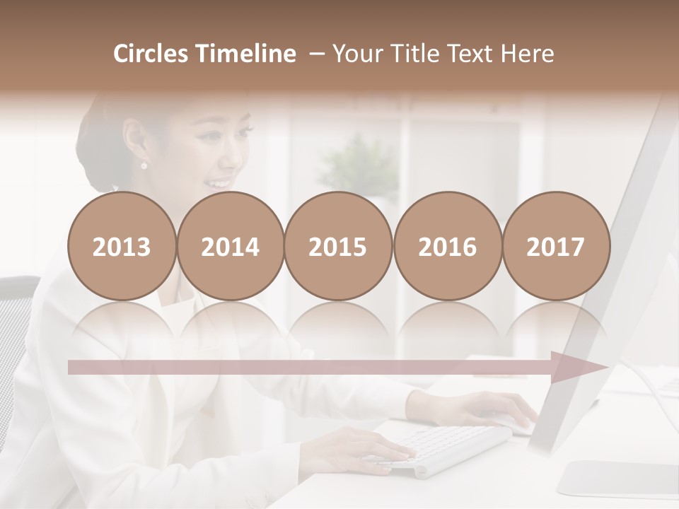 A Woman Sitting At A Desk Using A Computer PowerPoint Template