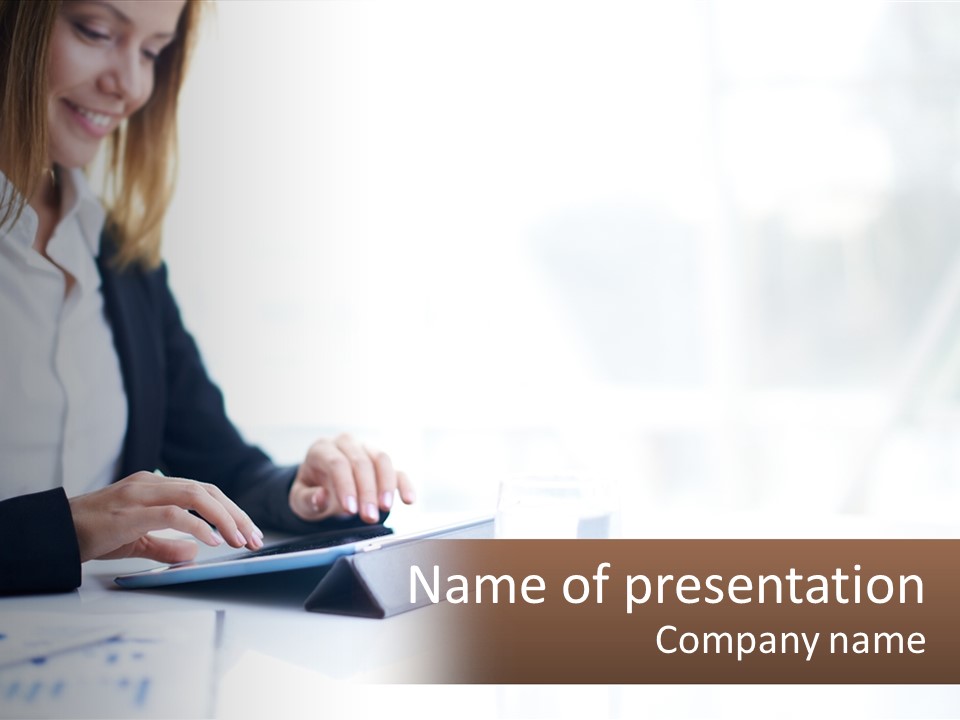 A Woman Sitting At A Table Using A Tablet Computer PowerPoint Template