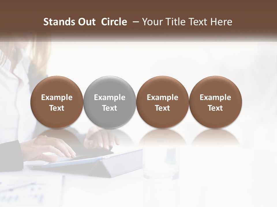 A Woman Sitting At A Table Using A Tablet Computer PowerPoint Template