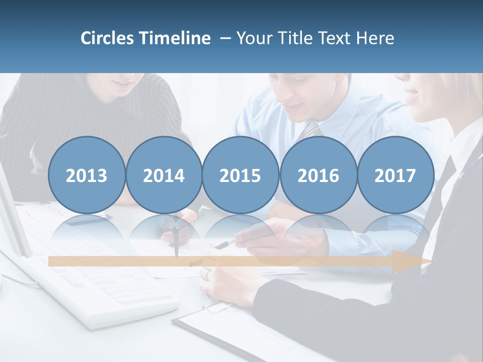 A Group Of People Sitting Around A Table With A Laptop PowerPoint Template