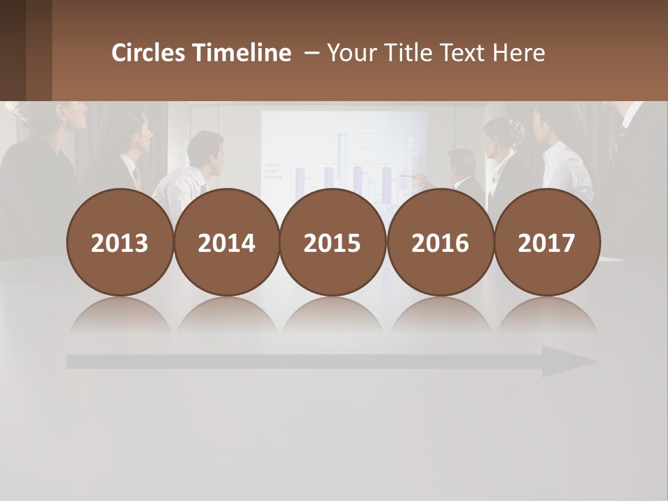 A Group Of People Sitting Around A Conference Table PowerPoint Template